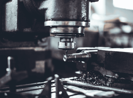 Close-up of a milling machine working on tool steel, with metal shavings visible.