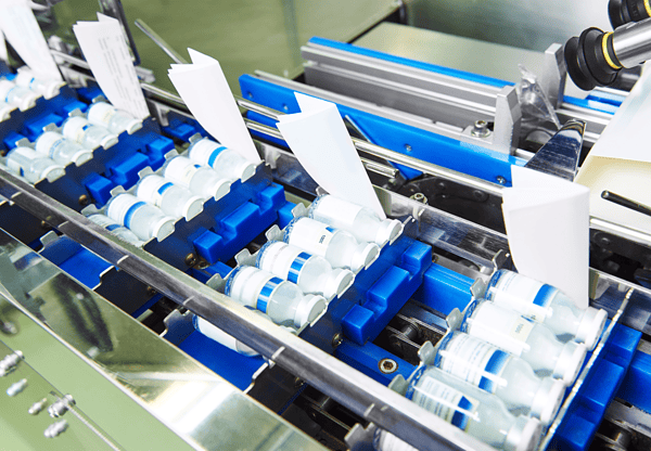 Automated production line with glass vials for pharmaceuticals, showcasing equipment made with 316L nuclear piping steel.