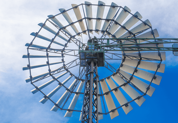 Close-up view of a traditional windmill against a blue sky.