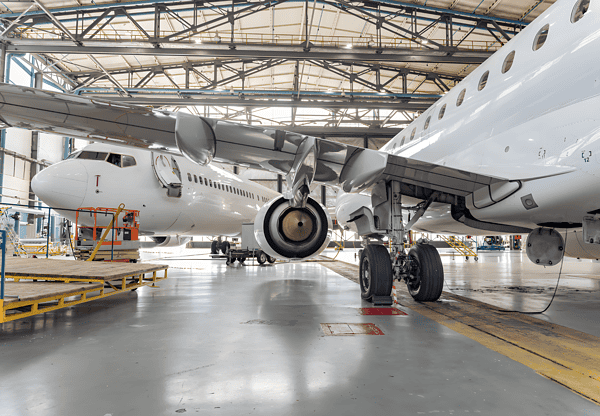 Avión en un hangar de mantenimiento, destacando los componentes que pueden utilizar barras de acero 4140 para mejorar su resistencia y fiabilidad.