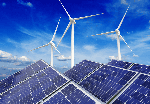 Solar panels and wind turbines against a bright blue sky with scattered clouds.