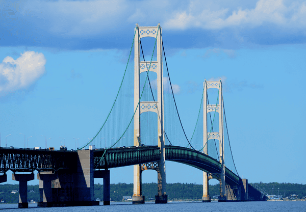 A long suspension bridge spanning over a body of water on a clear day.