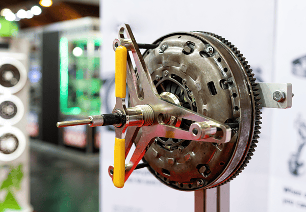 Close-up of a mechanical gear assembly with a yellow-handled tool attached.