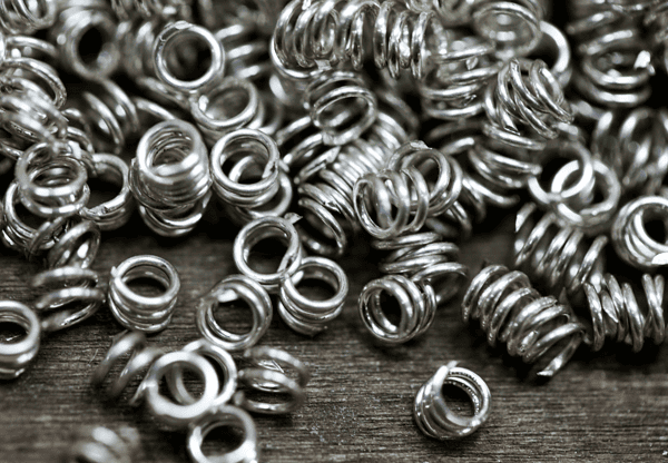 Pile of small metal coil springs.