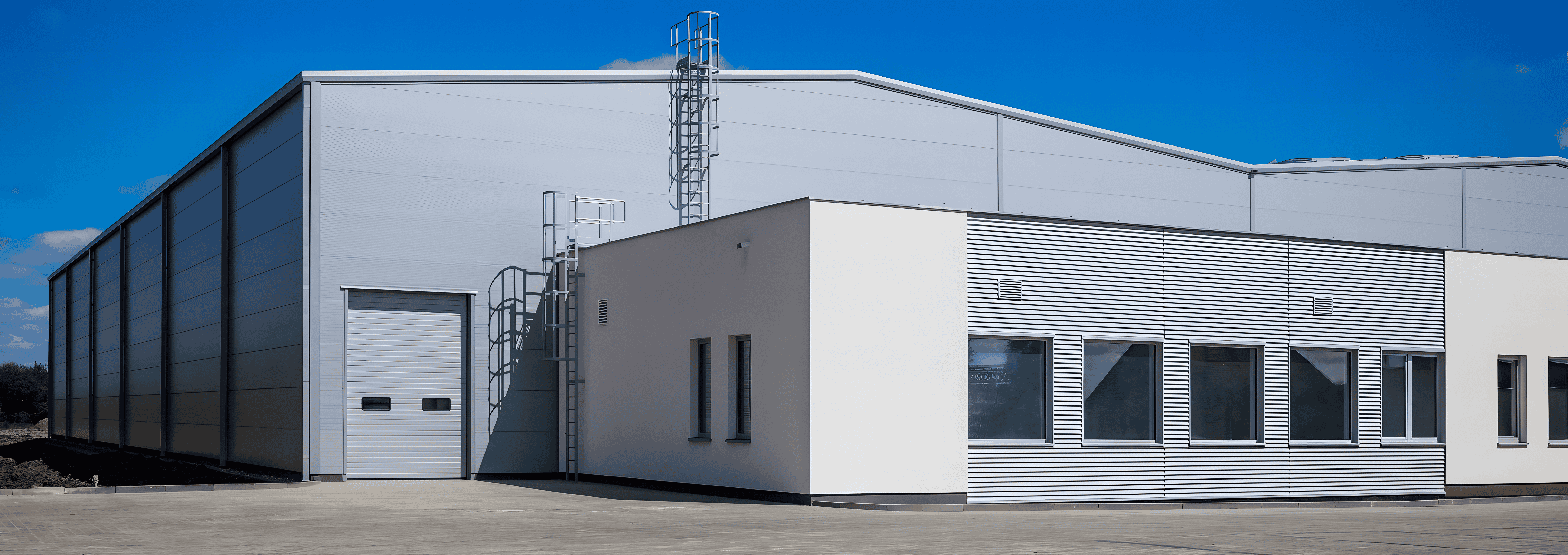 Exterior view of a modern industrial building used for the production and storage of alloy steel bars.