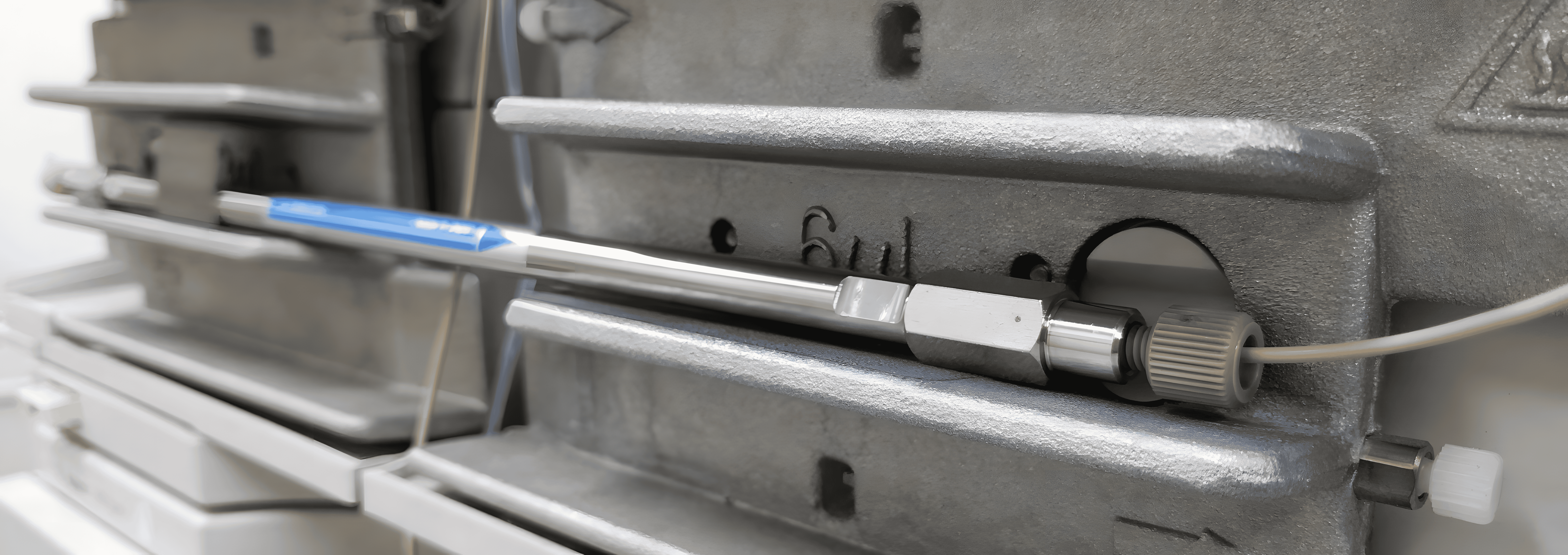 Close-up of a cold rolled steel bar connected to industrial equipment.