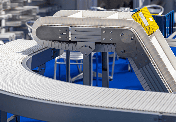 Curved conveyor belt system in an industrial setting.