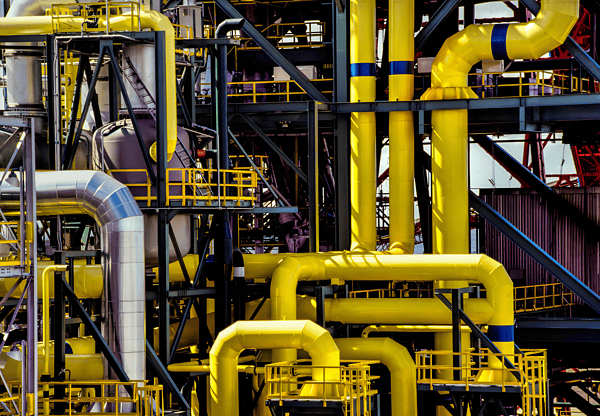 A complex network of yellow X70 pipeline steel pipes in an industrial facility.