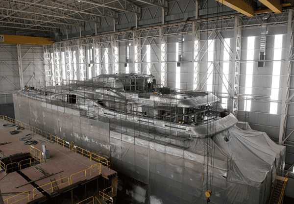 Large ship under construction in a shipyard.