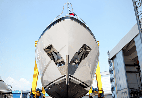 Front view of a boat being lifted in a shipyard.