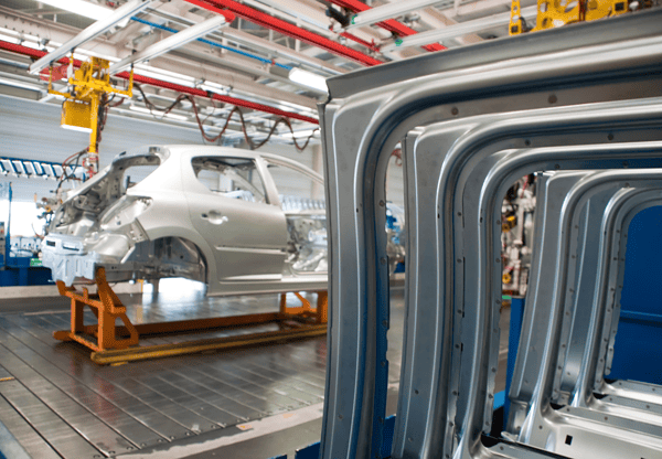 Automobile frames and body parts in an assembly line at a car manufacturing plant.