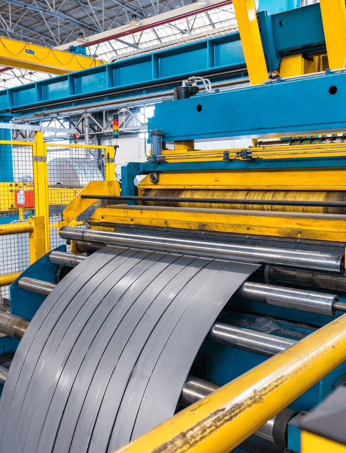 A machine cutting metal sheets in a factory.