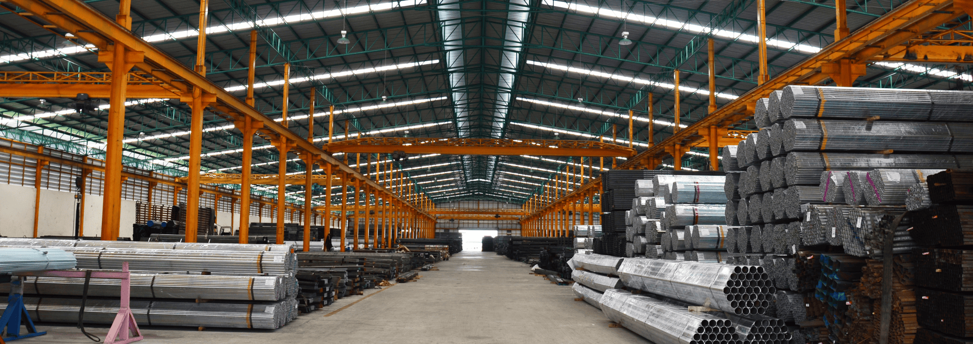 Warehouse interior with stacks of high-strength steel bars organized in rows, showcasing the robust storage and arrangement of the steel products.