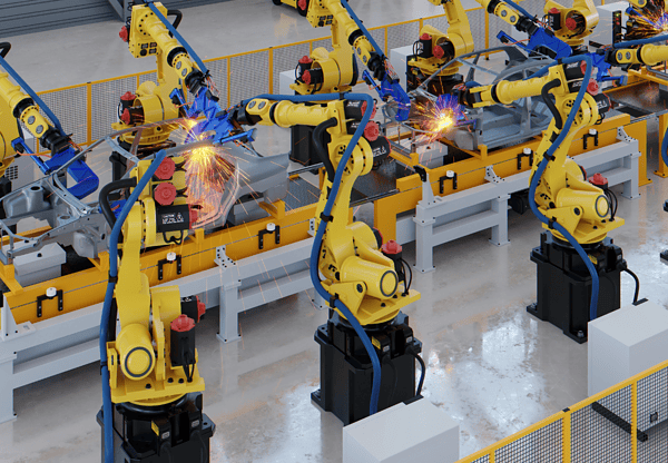 Multiple yellow robotic arms working on an assembly line in a manufacturing facility.