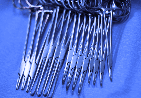 Close-up of several large metal hooks arranged on a blue surface.