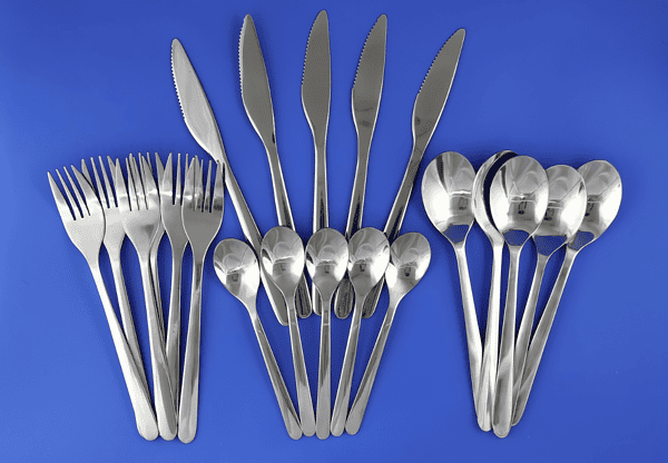 Set of silverware including knives, forks, and spoons arranged neatly on a blue background.