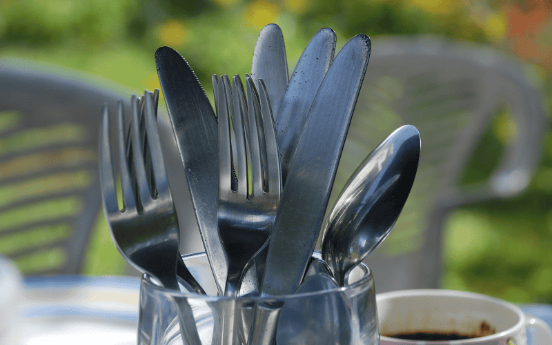 Stainless steel cutlery in a glass.