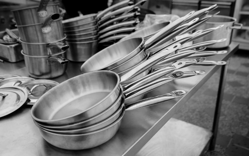 There are some stainless steel pans on the table.