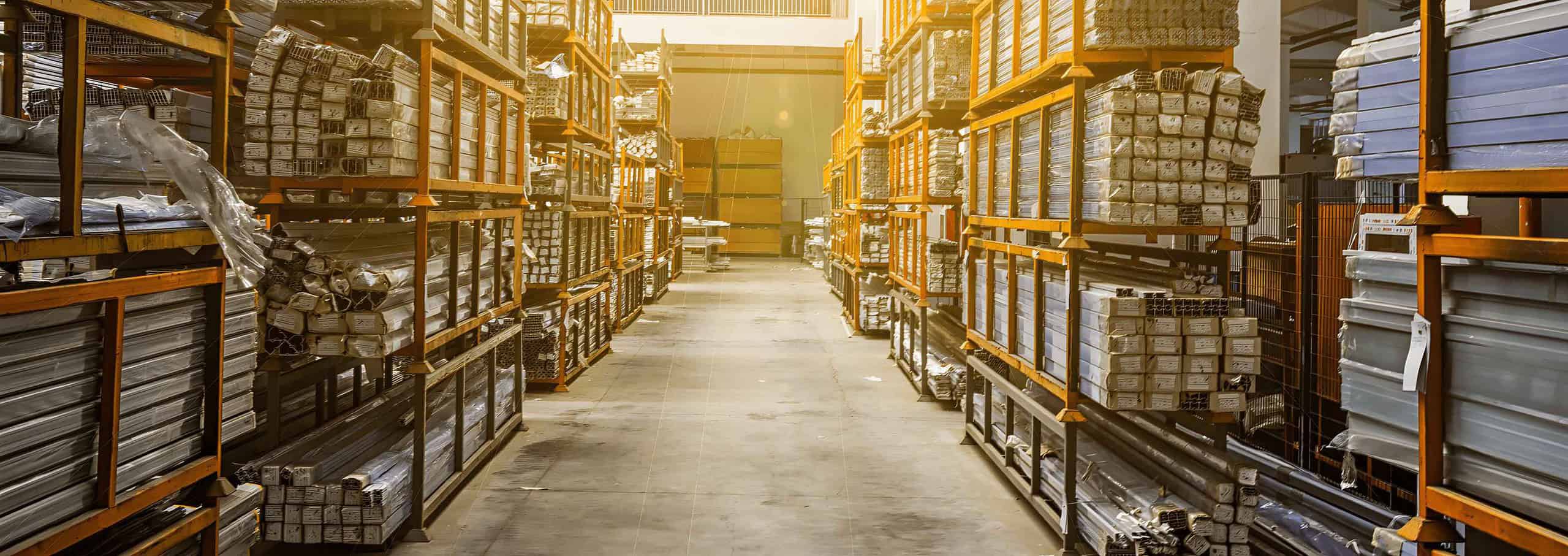 Warehouse with stacks of stainless steel bars organized on shelves.