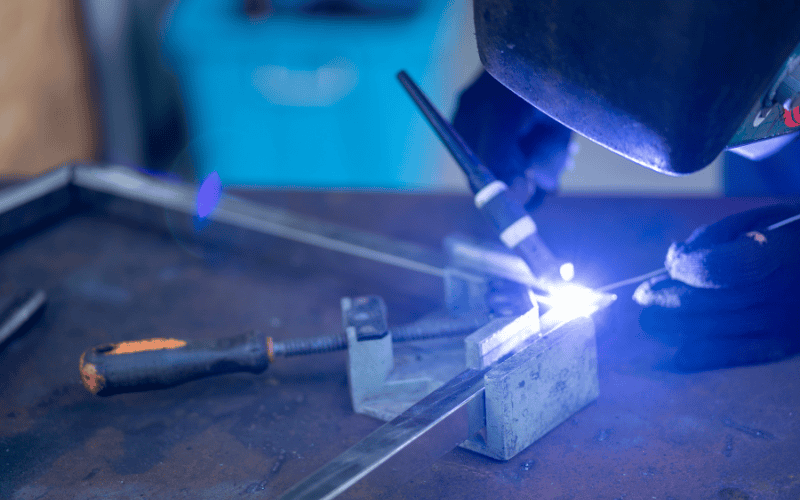 Person welding stainless steel components.