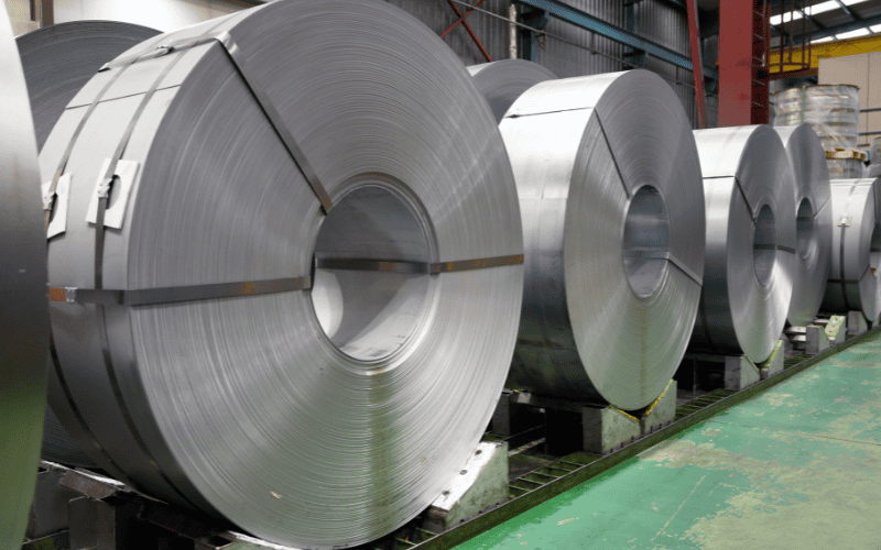 Large rolls of stainless steel in a warehouse.