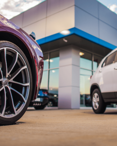 Close-up of car wheels in front of a modern building.