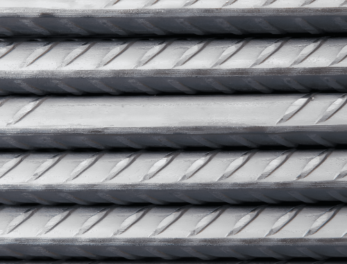 Close-up of stacked alloy steel bars with textured surfaces.