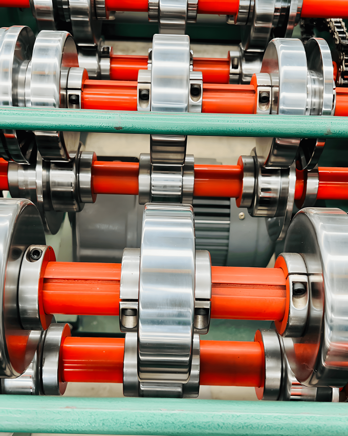 Close-up of machinery used in the processing of cold rolled steel bars, showing the intricate gears and components involved.