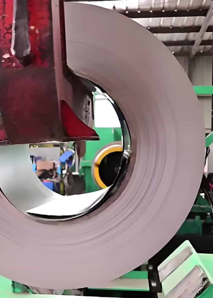A machine is lifting cold-rolled steel coils