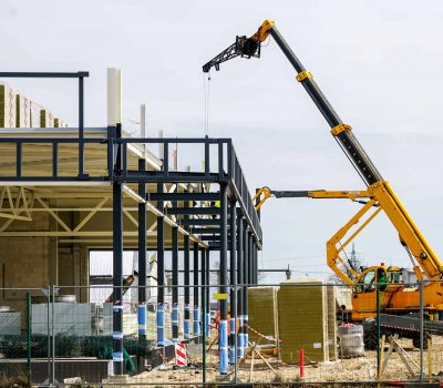 Construction site with a building framework and a crane in operation.