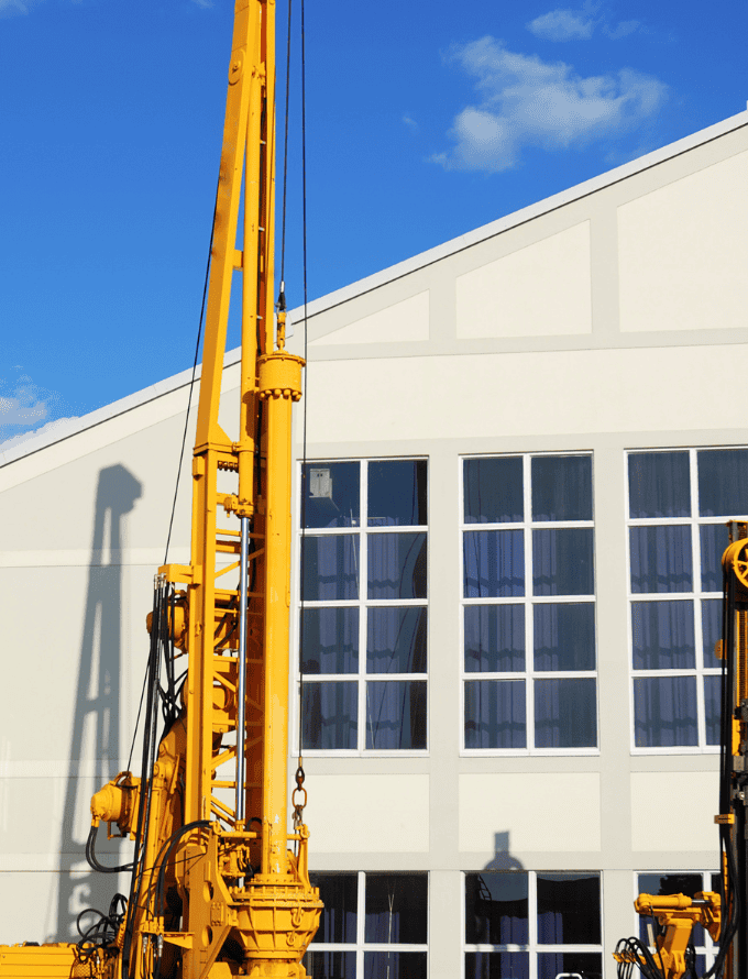 Construction machinery in front of a building, made with hot rolled steel bars.