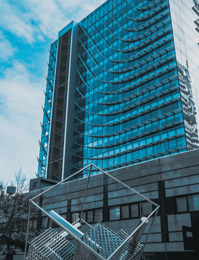 Modern building with a sculpture made of hot rolled steel bars in the foreground.