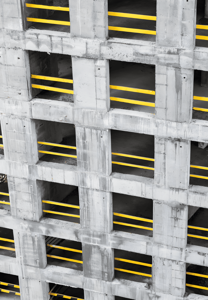 A construction site featuring a concrete building framework with visible plain carbon steel bars integrated for structural support.