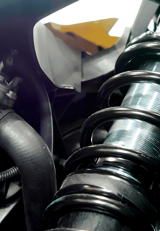 A close-up of a vehicle's suspension system featuring a coiled plain carbon steel bar spring, showcasing its use in automotive applications.