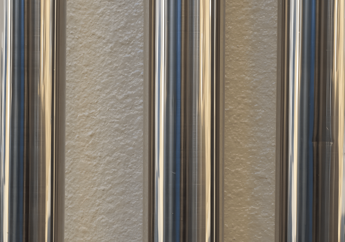 Close-up view of polished stainless steel bars aligned vertically.