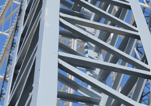 A close-up view of a structural steel bar framework with a blue sky background.