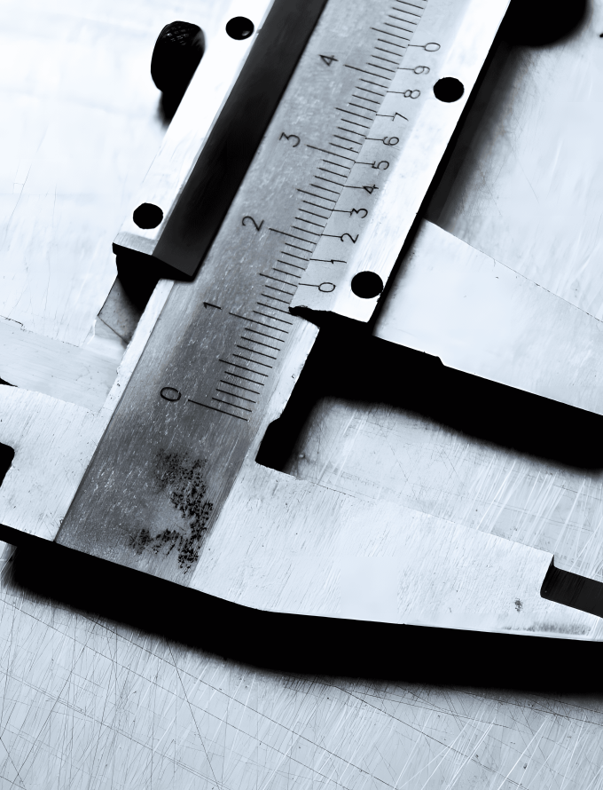 A caliper, made from tool steel bar, used for precision measurements, placed on a metal surface.