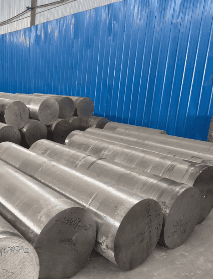 A stack of cylindrical advanced high strength steel bars placed on the floor.