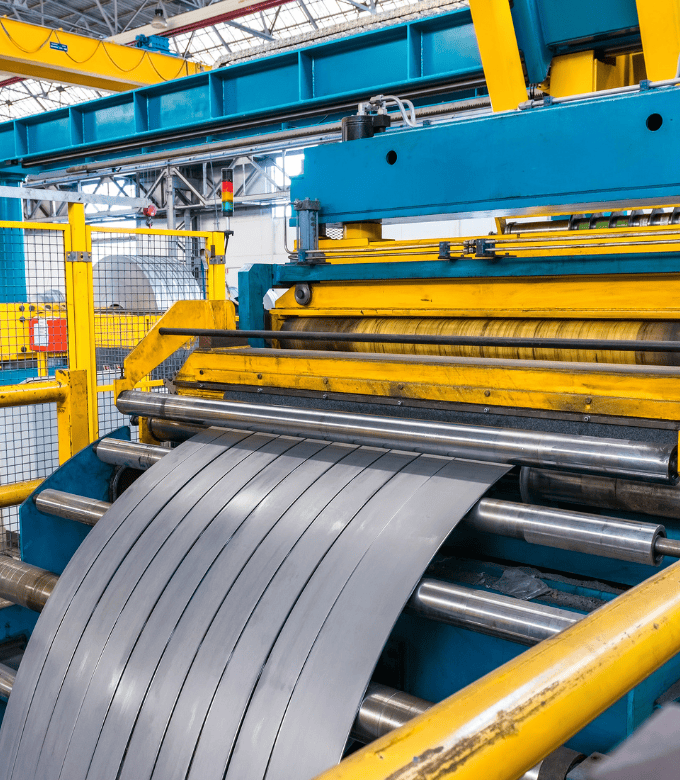 A machine cutting metal sheets in a factory.