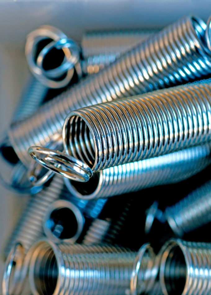 Close-up of coiled metal springs, showing detailed texture and reflections.