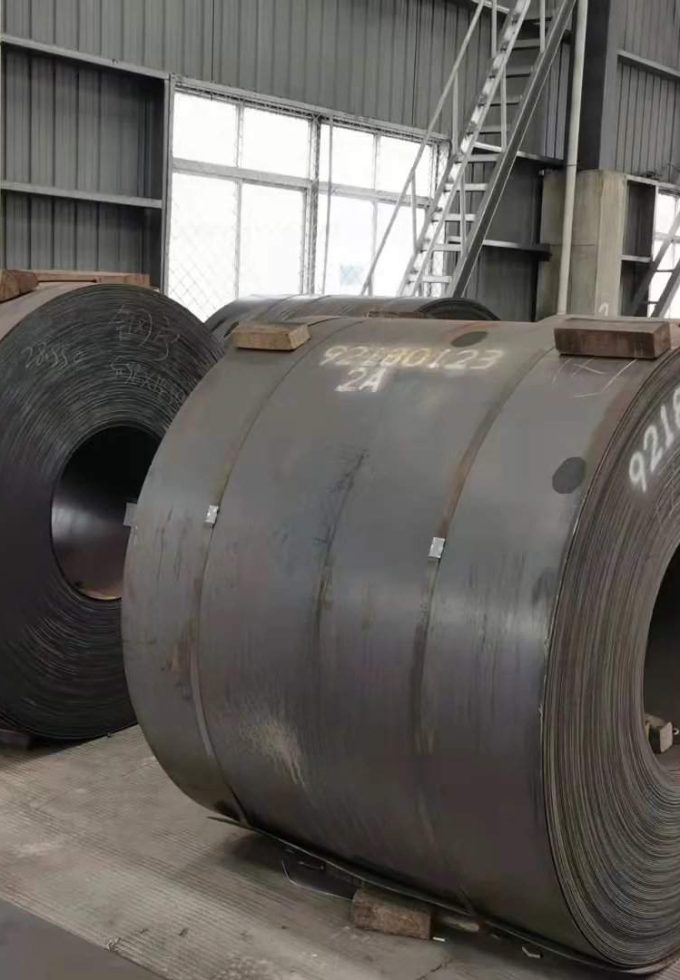 Coiled sheets of hot rolled steel stacked for storage and distribution.