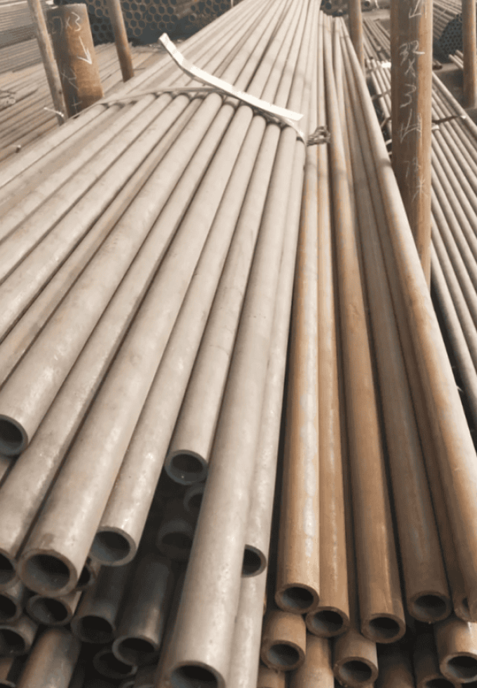 Cylindrical hot rolled steel pipes ready for transportation or further processing.