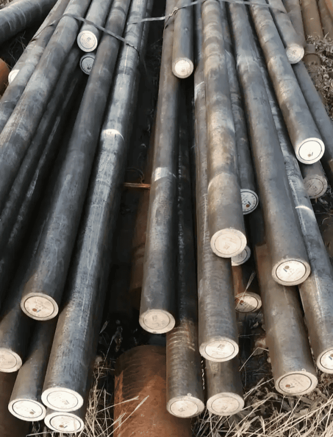 Hot rolled steel bars tied in bundles, arranged outdoors for industrial applications.