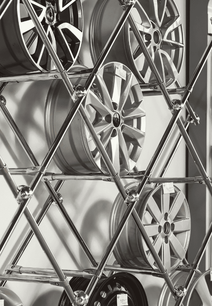 Display of car alloy wheels arranged on a metal rack.