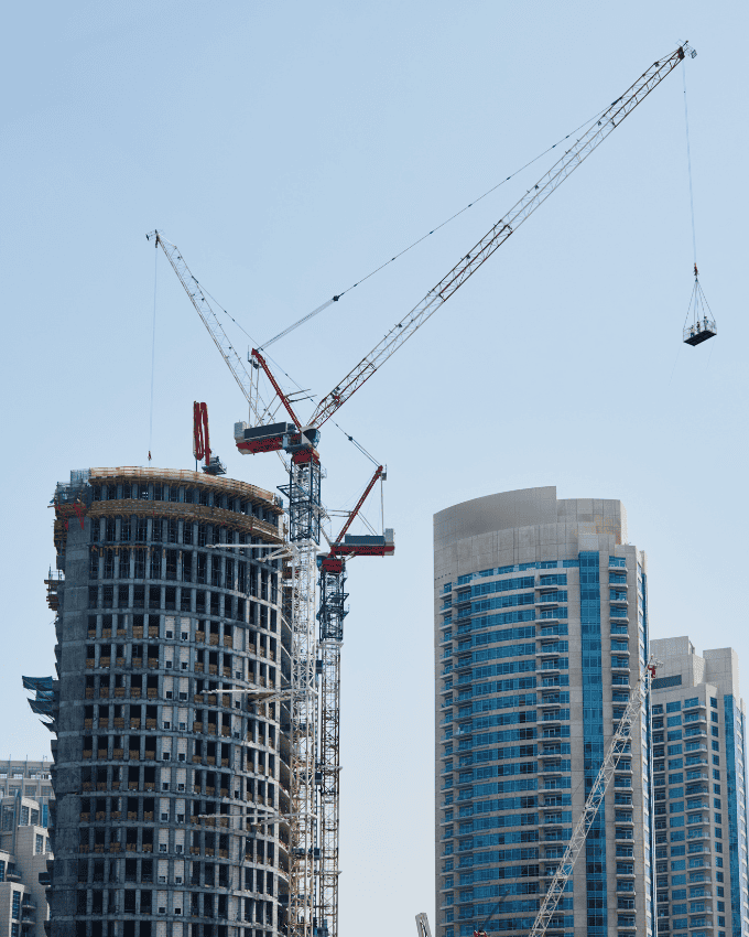 High-rise buildings under construction with cranes in the background.