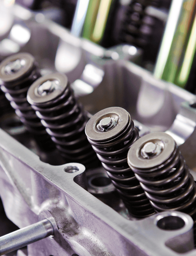 Close-up of medium carbon steel engine components with visible springs and bolts.