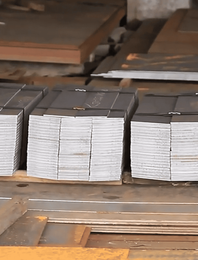 Bundles of small medium-carbon steel plates arranged in stacks.