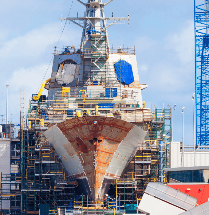 Close-up of a red and white ship's bow in a shipyard.