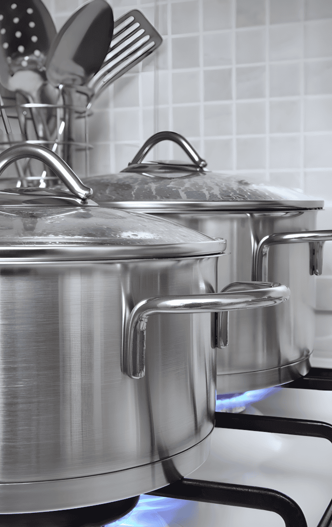 Stainless steel pots on a gas stove, showcasing the durability and quality of steel in cookware.