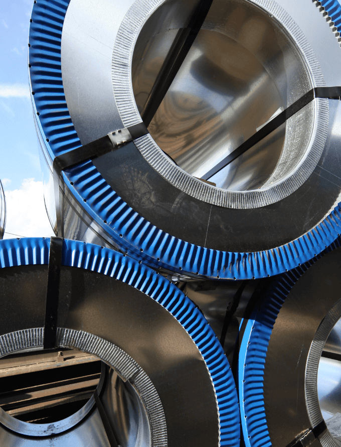 Stack of coiled steel sheets with blue edges.